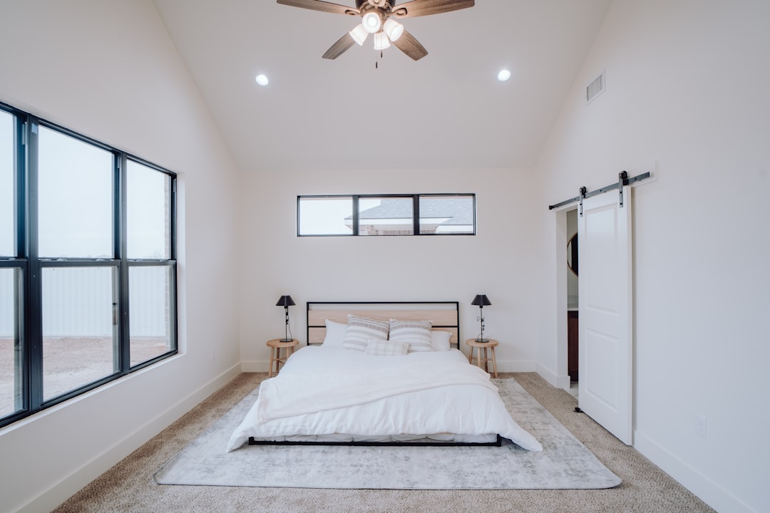 a-bedroom-with-a-bed-and-a-ceiling-fan-bmiqfwp9h0g