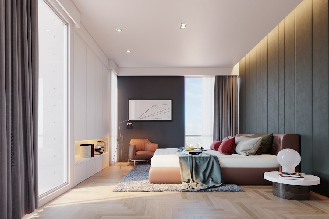 Modern Bedroom Design with Neutral Tones, Comfortable Furniture, and Large Windows Offering Scenic Views, Featuring a Stylish Bed, Cozy Armchair, and Elegant Lighting