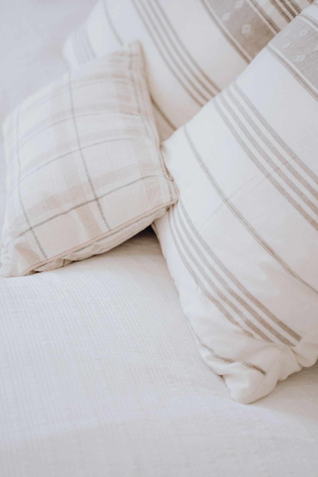 a-close-up-of-some-pillows-on-a-bed-2spwirthpws